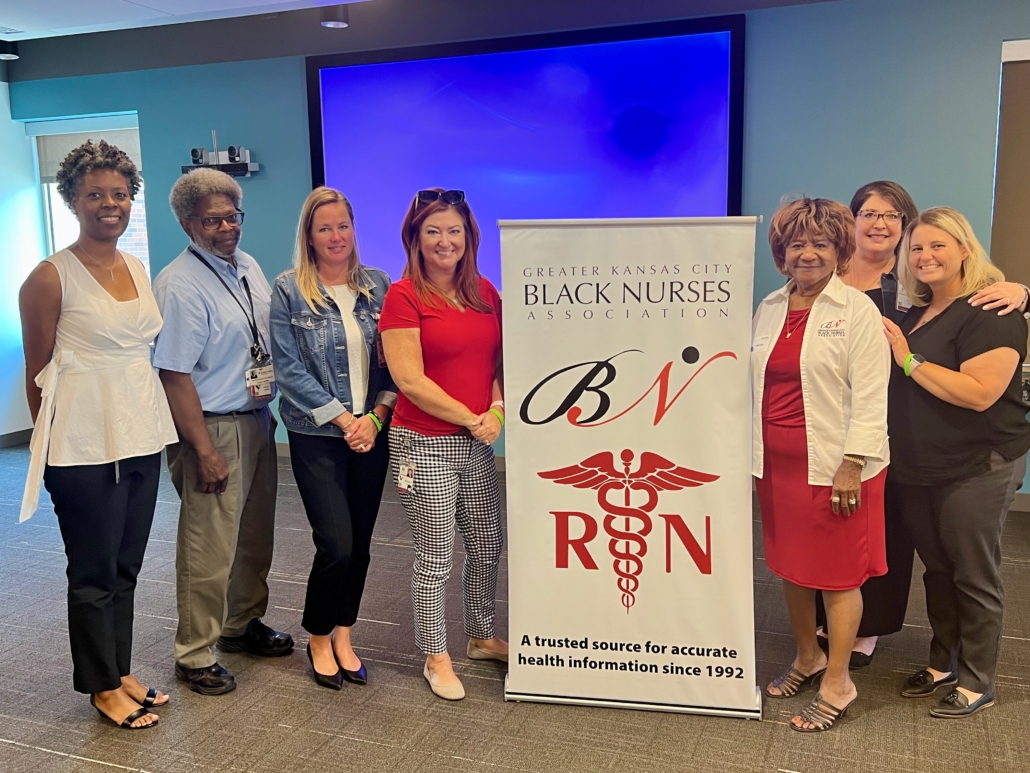 people next to a poster for Greater Kansas City Black Nurses Association