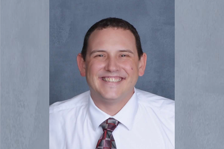 Joe Hecht, donor hero, wearing a white button-down shirt with a grey and maroon tie.