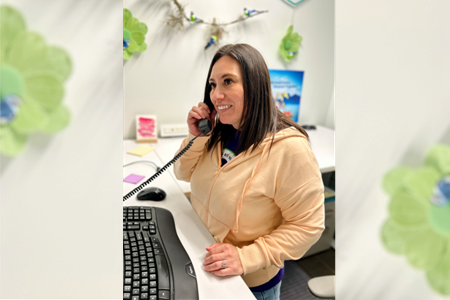 A woman talking on an office phone.